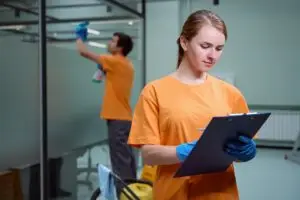 Cleaning copany employee following a checklist with her partner working