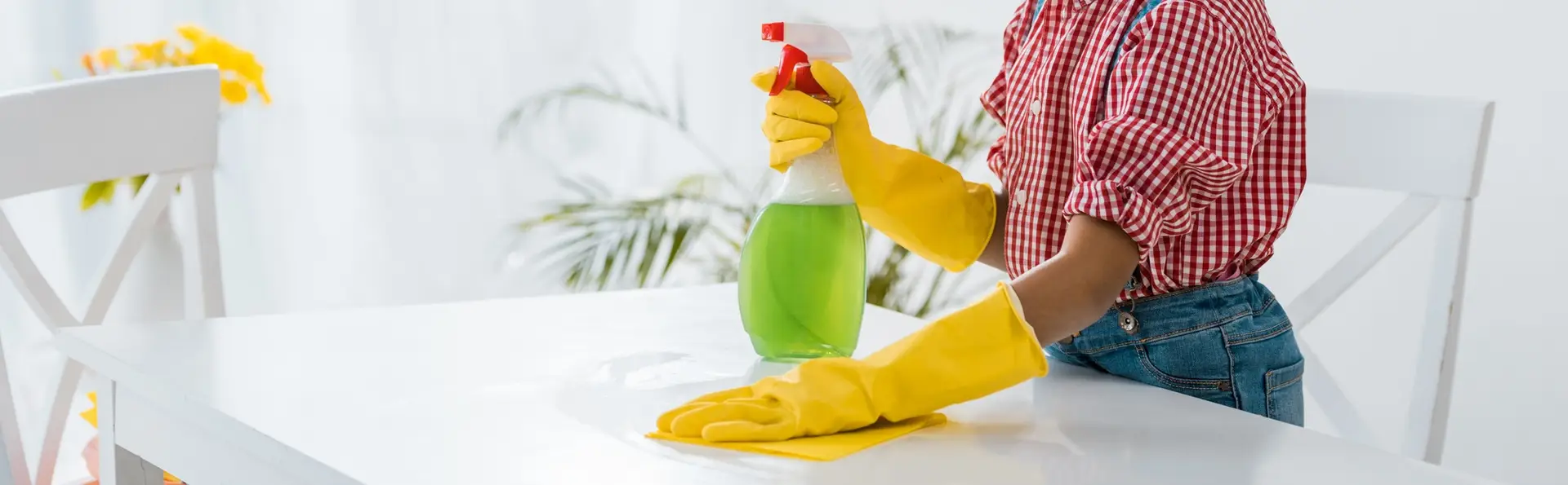 cleaner with a spray bottle wiping kitchen bench-top promoting eco friendly cleaning